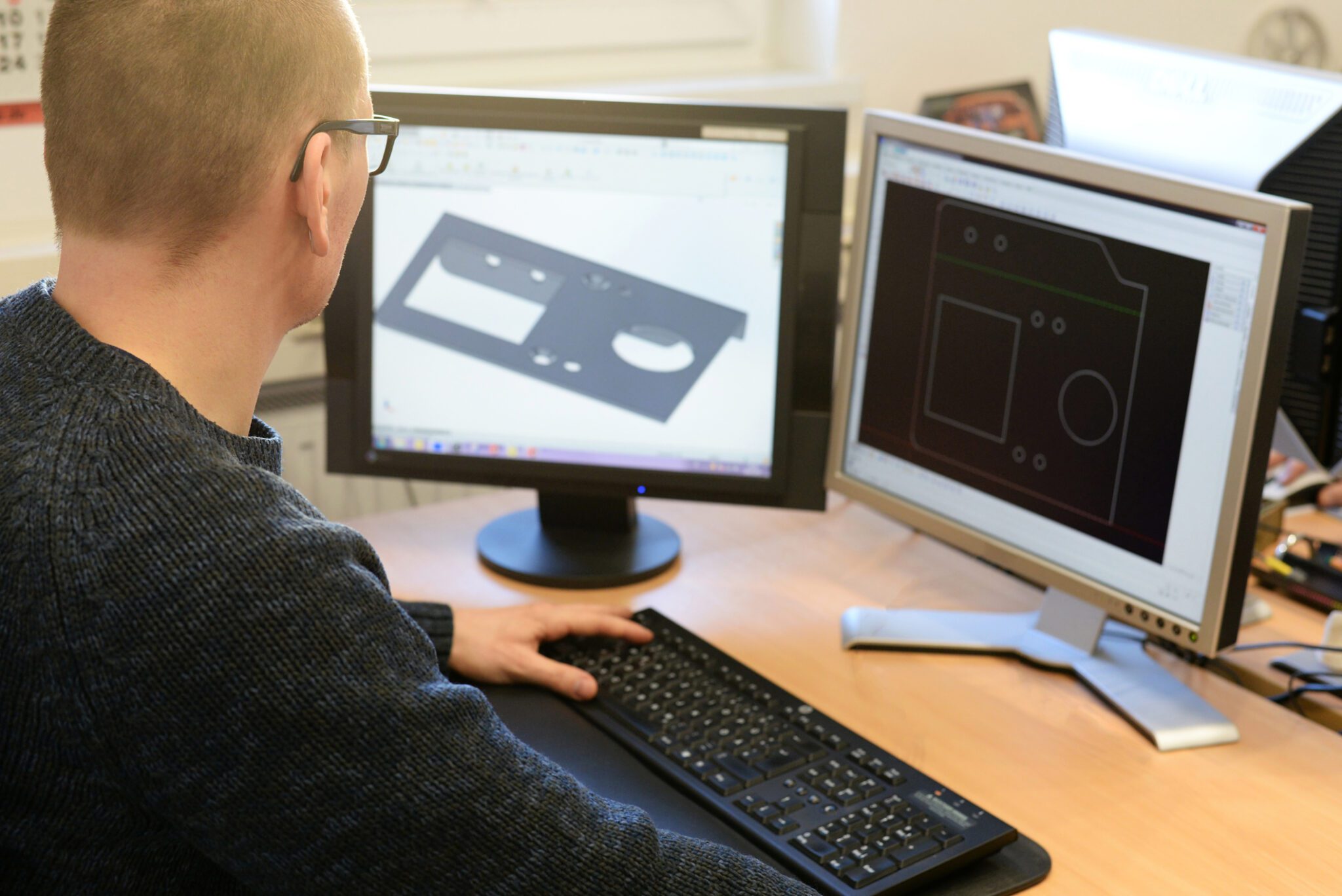 Design engineer working at his computer creating innovative ideas into custom metal components.